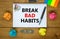 Break bad habits symbol. Words `Break bad habits` on white note. Wooden table, colored paper, paper clips, pen, coins. Business,