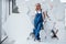 At the break time. Girl in blue uniform stands against abstract wall with white pieces of surface in the shape of