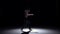 Breakdance dancer man in trousers with naked torso goes on dance on black, shadow, slow motion