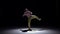 Breakdance dancer in yellow suit with naked torso dance on black, shadow, slow motion