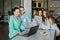 Breakfast in bathrobes, family of four women chatting over tea and viewing information on mobile devices at table in