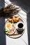 Breakfast in Bed Coffee Cup, Fried Egg, Bacon and Croissants on Wooden Tray. Trendy still life with interesting shadow.