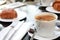 Breakfast in bed with hot coffee and croissants. Healthy breakfast kept on bed. Close up of a cup of tea with cookies on wooden