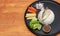 Breakfast in the black round plate on wooden floor. Fried mackerel and Rice with Spicy Shrimp Paste Dip and vegetable, Chinese