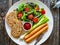 Breakfast - boiled sausages, bread and fresh vegetables served on wooden table, top view