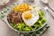 Breakfast bowl with quinoa, herbed corn, feta cheese and fried egg