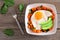 Breakfast bowl with sweet potato, egg, avocado and spinach over rustic wood