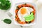 Breakfast bowl with sweet potato, egg, avocado and spinach over white wood