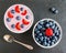 Breakfast bowl with yogurt, muesli, fresh blueberries and strawberries. Black stone background, top view