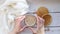 Breakfast with cappuccino and homemade fritters on a wooden table - 2. The girl`s hands twist a mug of coffee