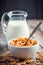 Breakfast cereal wheat flakes in bowl and milk jug