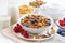 Breakfast with cereals flakes, nuts and berries on table
