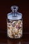 Breakfast cereals, oatmeal with candied fruits and nuts in a glass jar, brown background