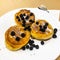 Breakfast for child. Delicious sweet pancakes with syrup, blueberries