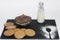 Breakfast with chocolate cereals, whole grain cookies, a small bottle of milk and the silhouette of a cooking spoon on a black
