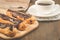 Breakfast with coffee cup and eclairs/breakfast with coffee cup and eclairs on a wooden table. Selective focus abd copy space