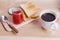 Breakfast with Coffee, toasts and strawberry jam on wooden table