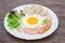 Breakfast consists of fried egg, ham, sausage, whole wheat bread, fresh vegetables, put plates on old wooden tables