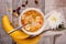 Breakfast, corn flakes with a spoon of raisins, bananas with a white chrysanthemum flower.