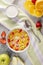 Breakfast cornflakes and strawberries with milk, yogurt and orange juice.