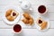 Breakfast for couple with toasts, heart shaped jam, croissants, and tea on white wooden table background