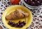 Breakfast croissant and cherries in a yellow plate, ripe peach, cherries in a glass bowl