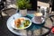 Breakfast with croissant with salmon, cream cheese and vegetables and a cup of cappuccino on the table early sunshine morning in a