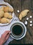 Breakfast with croissants and black coffee composition with girl hand on wooden retro background.
