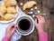 Breakfast with croissants and black coffee composition with girl hand on wooden retro background.