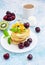 Breakfast with a cup of coffee and a stack of classic american pancakes served with black cherry, apricot, kiwi and mint. Blue