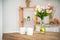 Breakfast cups and fruit. Spring tulips on the table. Wooden table in a bright rustic-style kitchen. Scandinavian style in the int