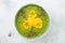 Breakfast detox green smoothie bowl topped with superfoods, chia seeds, bee pollen and edible flowers. Overhead, flat lay