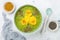 Breakfast detox green smoothie bowl topped with superfoods, chia seeds, bee pollen and edible flowers. Overhead, flat lay