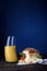 Breakfast egg sandwich with orange juice on wooden table, dark b