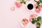 Breakfast feminine composition with roses flowers, sweet cookies and cup of coffee on pink background. Flat lay, top view