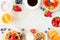 Breakfast frame of fruits, cereal, waffles, yogurt, coffee and milk. Top view over a bright stone background.