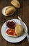 Breakfast with fresh buns and butter, strawbery jam on wooden background. Vertical image.