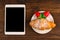 Breakfast with fresh croissants, fresh strawberry on a rustic wooden background, top view. tablet pc.