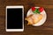 Breakfast with fresh croissants, fresh strawberry on a rustic wooden background, top view. tablet pc.