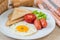 Breakfast with fried egg, toast, sausage and vegetable on plate