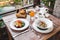 Breakfast with fruit plate, basket with croissants and fruit salad wooden table