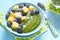 Breakfast green smoothie bowl topped with fruits