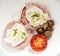 Breakfast with ham sandwich, tomato and mushrooms served on a white plate