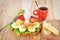 Breakfast with hard boiled eggs, sliced in halves, cup of tea, salad, tomatoes, cheese and bread on the red plate