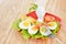 Breakfast with hard boiled eggs, sliced in halves, salad, tomatoes, cheese and bread on the red plate