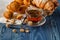 Breakfast with herbal tea and croissant on wooden vintage table