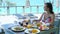 Breakfast in hotel with sea view. Smiling woman enjoy food in outdoor cafe