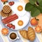 Breakfast illustration. Picnic outdoor scene, top view. Fried eggs, bacon, waffles, croissants, coffee, fruits and plants