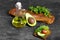 Breakfast ingredients on a stone background. Baguette, olive oil, salad and a cut avocado for an avocado toast cooking.