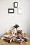 Breakfast in kitchen with photo frames on white wall. Croissants, figs, coffee, bread on wooden table background, space for layout